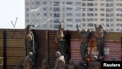 Lính Mỹ đặt dây thép gai lên bức tường biên giới ở San Diego