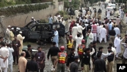 Officials and rescue volunteers gather at the bombing site in Peshawar, Pakistan, September 3, 2012.