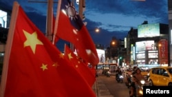 FILE - Flags of China and Taiwan flutter next to each other during a rally calling for peaceful reunification, days before the inauguration ceremony of President Tsai Ing-wen, in Taipei, Taiwan, May 14, 2016. 