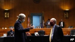 FILE - In this Thursday, May 7, 2020 file photo, National Institutes of Health Director Dr. Francis Collins, left, speaks with Chairman Sen. Lamar Alexander, R-Tenn., prior to a Senate hearing on new coronavirus. (AP Photo/Andrew Harnik, Pool)