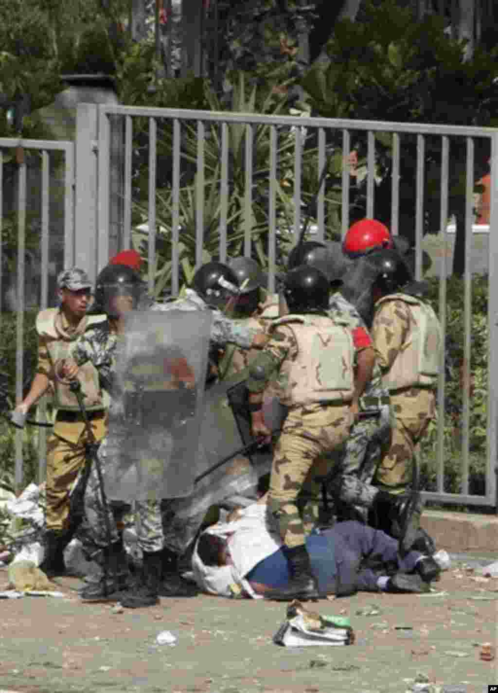 Egyptian soldiers surround a downed protester during clashes outside the Ministry of Defense in Cairo, Egypt, Friday, May 4, 2012. Egyptian armed forces and protesters clashed in Cairo on Friday, with troops firing water cannons and tear gas at demonstrat