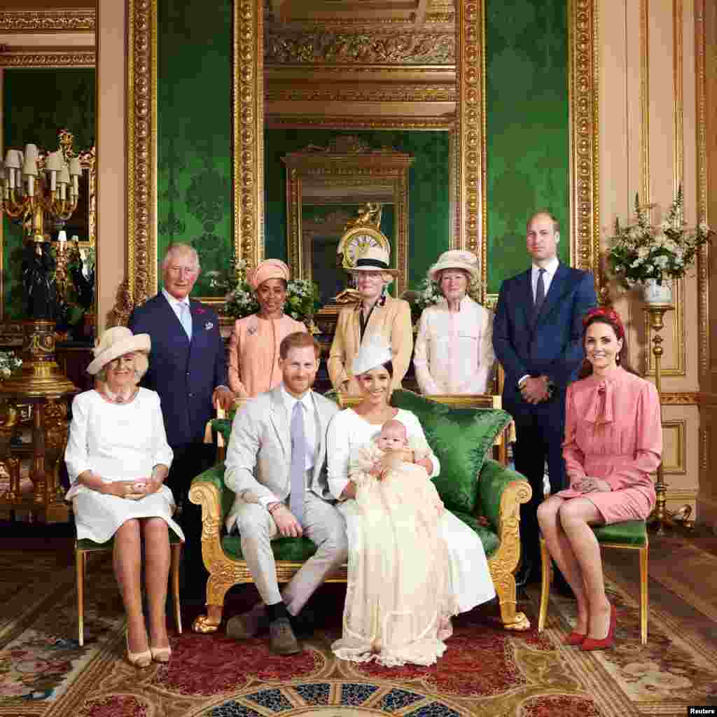 This official photograph released by the Duke and Duchess of Sussex shows Britain&#39;s Prince Harry, Duke of Sussex (centre left), and his wife Meghan, Duchess of Sussex holding their baby son, Archie Harrison Mountbatten-Windsor flanked by (L-R) Britain&#39;s Camilla, Duchess of Cornwall, Britain&#39;s Prince Charles, Prince of Wales, Ms Doria Ragland, Lady Jane Fellowes, Lady Sarah McCorquodale, Britain&#39;s Prince William, Duke of Cambridge, and Britain&#39;s Catherine, Duchess of Cambridge in the Green Drawing Room at Windsor Castle, west of London, July 6, 2019.