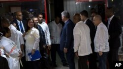 El presidente de Cuba, Miguel Díaz-Canel, en el centro, habla con los médicos cubanos a su regreso de Brasil en La Habana (AP Foto / Desmond Boylan)