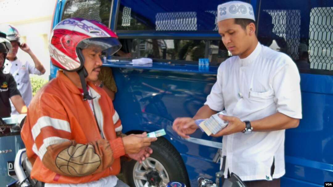 Seorang warga sedang menukarkan uang tunai di layanan Drive Thru Bank Indonesia (foto: VOA).