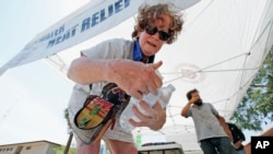 Salvation Army volunteer Dyane Welt pulls bottles of water from an ice cooler at a hydration station in an effort to beat the rising temperatures expected to hit 115 degrees in Phoenix, June 20, 2016. 