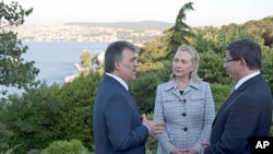 Turkish President Abdullah Gul (L) speaks with US Secretary of State Hillary Clinton and Turkish Foreign Minister Ahmet Davutoglu in front of the Bosphorus Sea in Istanbul, July 15, 2011