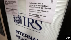 FILE- Doors at the Internal Revenue Service (IRS) in the Henry M. Jackson Federal Building are locked and covered with blinds as a sign posted advises that the office will be closed during the partial government shutdown in Seattle, Jan. 16, 2019. 