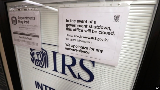 FILE - Doors at the Internal Revenue Service in the Henry M. Jackson Federal Building are locked and covered with blinds as a sign posted advises that the office will be closed during the partial government shutdown in Seattle, Jan. 16, 2019.