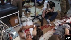 Wounded men receive treatment at a local clinic after airstrikes hit in Aleppo, Syria, Sept. 24, 2016. 