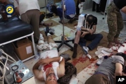 In this photo provided by the Syrian Civil Defense group known as the White Helmets, shows wounded men receiving treatment at a local clinic after airstrikes hit in Aleppo, Syria, Sept. 24, 2016.