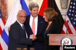 Chief Palestinian negotiator Saeb Erekat (L-R), U.S. Secretary of State John Kerry and Israel's Justice Minister Tzipi Livni shake hands at the end of talks in Washington, July 30, 2013.