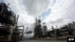 FILE - Thick black smoke billows from a pencil-thin chimney at the Port Harcourt Refining Company Limited, Rivers State on Sept. 16, 2015. The Port Harcourt refinery is Nigeria's oldest, built in 1965. In recent years, however, it became a byword for corruption, a murky, state-run body where billions of dollars in revenue apparently disappeared.