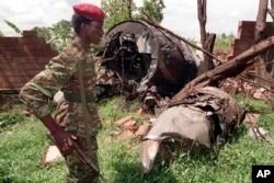 FILE— A Rwanda Patriotic Front (RPF) rebel walks by the the site of a April 6 plane crash which killed Rwanda's President Juvenal Habyarimana in this May 23, 1994 file photo in Kigali.