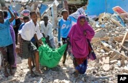 FILE - Somalis carry away the body of a civilian who was killed in a car bomb attack in Mogadishu, Somalia, June 20, 2017.