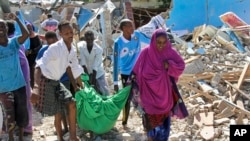 Somalis carry away the body of a civilian who was killed in a car bomb attack in Mogadishu, Somalia, June 20, 2017.