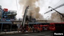 Pemadam kebakaran berusaha mengatasi kobaran api di pasar ikan Tsukiji di Tokyo, Jepang hari Kamis (3/8). 