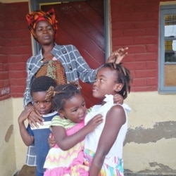 Feniya Mbewe watches over her children at her home in Malawi. (Lameck Masina/VOA)