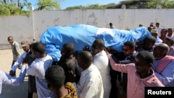 FILE - Relatives carry the dead body of Somalia's public works minister Abbas Abdullahi Sheikh Siraji who was shot and killed in Somalia's capital Mogadishu, May 4, 2017. 