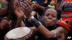Women take part in a drumming session in downtown Johannesburg, Friday, March 8, 2013 to protest against violence against women and children. 