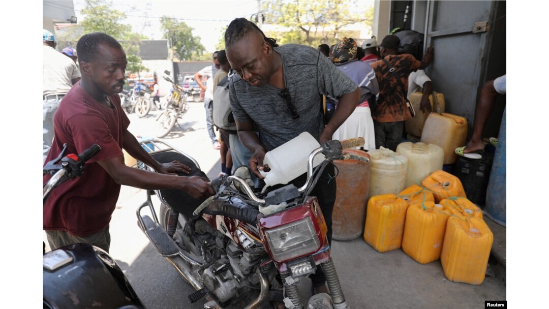 Seorang pria mengisi bensin untuk motornya di sebuah stasiun pengisian bahan bakar di tengah kekerasan yang meluas dan geng-geng bersenjata memperluas kekuasaannya di ibu kota Haiti, Port-au-Prince, Jumat, 29 Maret 2024. (Foto: Ralph Tedy Erol/Reuters)