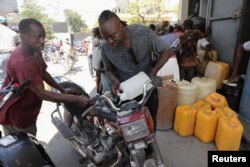 Seorang pria mengisi bensin untuk motornya di sebuah stasiun pengisian bahan bakar di tengah kekerasan yang meluas dan geng-geng bersenjata memperluas kekuasaannya di ibu kota Haiti, Port-au-Prince, Jumat, 29 Maret 2024. (Foto: Ralph Tedy Erol/Reuters)