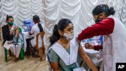 A health staff administers vaccine for COVID-19 to teens at a school in Kolkata, India, Jan. 3, 2022.