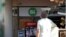 A man stands nearby as a "24/7" open sign is seen at the entrance of a food store in Tel Aviv, Israel, Sept. 20, 2016.