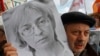 FILE - A participant holds a portrait of assassinated human rights activist Anna Politkovskaya during a "March against hatred" in St. Petersburg, Oct. 27, 2012.