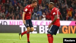 Thomas Mueller (G) et Jerome Boateng du Bayern Munich jubilent après leur but, lors d’un match de la bundesliga, le 24 août 2018. 