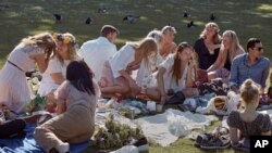 FILE - People picnic during the annual Midsummer celebrations in Stockholm, Sweden, June 19, 2020.