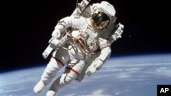 Foto 7 Februari 1984 yang dirilis NASA menunjukkan astronot Bruce McCandless II pada saat berjalan di luar angkasa atau spacewalk beberapa meter dari kabin pesawat ulang-alik yang mengorbit Bumi, Challenger, menggunakan alat pendoron berbahan nitrogen, Manned Maneuvering Unit.