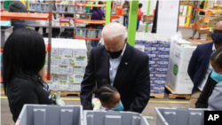 Një fëmijë përqafon Presidentin Biden ndërsa ai viziton Depon e Ushqimeve në Hjuston, Teksas (26 shkurt 2021)