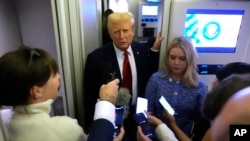 El presidente Donald Trump habla con periodistas a bordo del Air Force One en ruta desde Miami a la Base Conjunta Andrews, Maryland, el lunes 27 de enero de 2025, mientras la secretaria de prensa de la Casa Blanca, Karoline Leavitt, escucha.