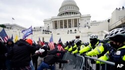 Сторонники Трампа пытаются прорваться к зданию Капитолия. 6 января 2020.