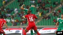 Pesepak bola Palestina Abdelatif Bahdari (tengah) berancang-ancang mengambil bola dengan seorang pesepak bola Irak dalam pertandingan persahabatan antara Irak dan Palestina di Stadion Basra Sports City, 8 Mei 2018, di Kota Basra, sebelah selatan Irak. 