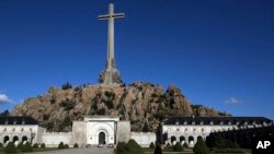 A monk walks in front of The Valley of the Fallen mausoleum near El Escorial, outskirts of Madrid, Spain, Oct. 13, 2019. 