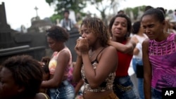 Friends and relatives of Paulo Henrique Oliveira, a 13-year-old who local media said was killed by a stray bullet during a shootout between police and criminals, cry during his burial in Rio de Janeiro, Brazil, April 26, 2017. 