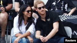 Britain's Prince Harry sits with girlfriend actress Meghan Markle to watch a wheelchair tennis event during the Invictus Games in Toronto, Sept. 25, 2017.