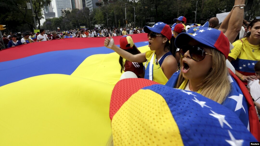 FILE - People carry a giant Venezuelan flag during a protest of Venezuelan citizens residing in Mexico, against the government of Venezuela's President Nicolas Maduro and the violence resulting from anti-government protests, in Mexico City, Feb. 23, 2014.
