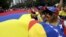 FILE - People carry a giant Venezuelan flag during a protest of Venezuelan citizens residing in Mexico, against the government of Venezuela's President Nicolas Maduro and the violence resulting from anti-government protests, in Mexico City, Feb. 23, 2014.