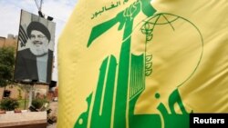 Una bandera de Hezbolá ondea junto a un retrato del líder la organización Sayyed Hassan Nasrallah, en las calles de Sidon, Líbano, el 7 de julio de 2020.