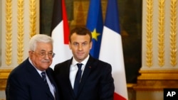 Le président français Emmanuel Macron, à droite, serre la main du président palestinien Mahmoud Abbas lors d'une conférence de presse conjointe à l'Elysée après leurs entretiens à Paris, vendredi 22 décembre 2017. (AP Photo / François Mori, Piscine)