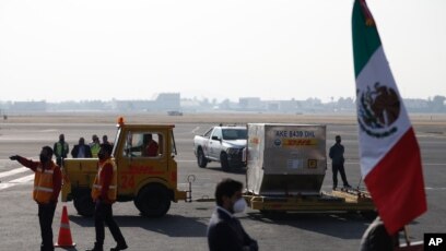 The first shipment of the Pfizer COVID-19 vaccine to Mexico is transported on the tarmac after being unloaded from a DHL cargo plane at the Benito Juarez International Airport in Mexico City, Wednesday, Dec. 23, 2020. (AP Photo/Eduardo Verdugo)