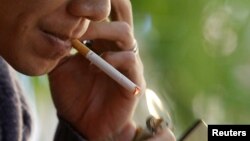 A man lights a cigarette at a cafe in Hanoi, Vietnam, November 12, 2012.