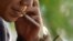 A man lights a cigarette at a cafe in Hanoi, Vietnam, November 12, 2012.