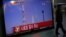 A passenger walks past a TV screen broadcasting the news that the launch of Korea Space Launch Vehicle-1 (KSLV-1) was cancelled due to a problem in the upper second-stage rocket, at a railway station in Seoul, November 29, 2012.