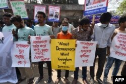 FILE - Activists hold placards during a demonstration demanding the repeal of the Digital Security Act, in Dhaka, Feb. 27, 2021, following the death of writer Mushtaq Ahmed in jail months after his arrest.