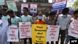 FILE - Activists hold placards during a demonstration demanding the repeal of the Digital Security Act, in Dhaka, Feb. 27, 2021, following the death of writer Mushtaq Ahmed in jail months after his arrest.