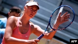 FILE - Russian tennis player Maria Sharapova touches her racket at the end of her match against Colombian Mariana Duque Marino in Madrid on May 5, 2015. 