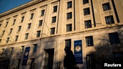 Una mujer camina por frente al edificio del Departamento de Justicia de Estados Unidos en Washington DC.